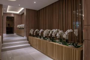 多哈Corp Hotel Apartments and Spa的走廊上设有楼梯,陈列着白色鲜花