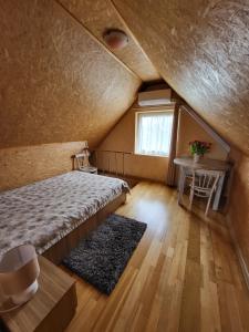 德鲁斯基宁凯Namelis Rugilė的一间卧室配有一张床、一张桌子和一个窗户。