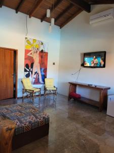 皮雷诺波利斯Brisa da Serra Hotel Pousada Pirenopolis的客厅配有电视和桌椅