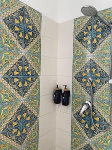 陶尔米纳Taormina Rooms Panoramic Apartments的浴室设有蓝色和黄色瓷砖淋浴。