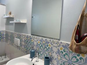 陶尔米纳Taormina Rooms Panoramic Apartments的一间带水槽和镜子的浴室