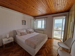 拉巴克Apartment Nadija的一间卧室设有一张床和木制天花板