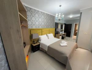 萨兰达萨兰达皇家酒店的酒店客房,配有一张床和吊灯