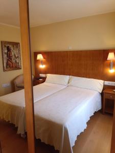 LarragaHotel Villa de Larraga的一间卧室配有两张床和两盏灯。