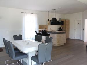 Burk´s Scheune Comfortable holiday residence的厨房以及带白色桌椅的用餐室。