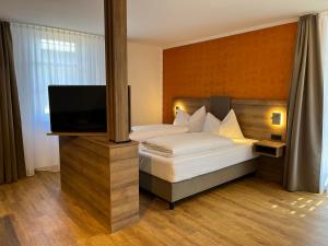 慕尼黑WESTSIDE Hotel的一间卧室配有一张床和一台平面电视