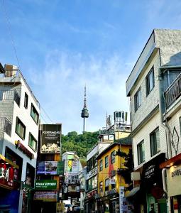 首尔Look Home Guesthouse的一条城市街道,后面有电视塔