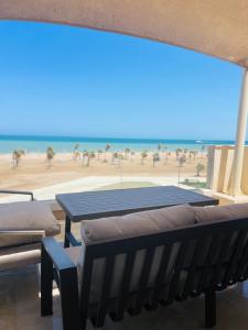 赫尔格达Mangroovy Residence El Gouna - Grovin的一张桌子和长凳,享有海滩美景