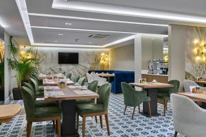 伊斯坦布尔Rayelin Hotel Istanbul Old City Special Category的餐厅设有木桌和绿色椅子