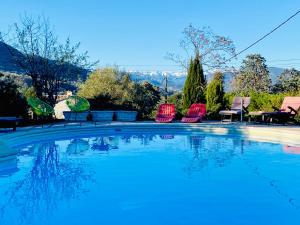 拉戈德Villa Côte d'Azur piscine privée的一个带三把椅子和一张桌子的游泳池