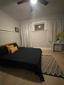 克利夫顿Suite Dream Clifton 27的一间卧室配有黑色的床和吊扇