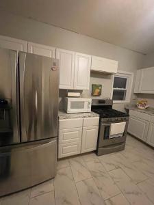 克利夫顿Suite Dream Clifton 27的厨房配有不锈钢冰箱和白色橱柜