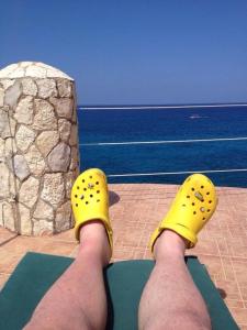 尼格瑞尔home sweet home resort的双脚上穿黄鞋的人看着大海