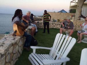 尼格瑞尔home sweet home resort的一群人坐在墙上弹吉他