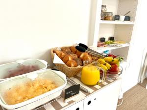 文尼斯塔特Hotel Villa Klasen的厨房柜台提供早餐食品和橙汁