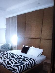 拉各斯N.V HOTEL AND RESORT BEACH view的一间卧室配有一张带斑马打印床头板的床