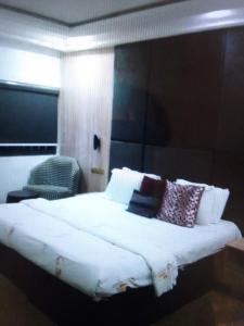 拉各斯N.V HOTEL AND RESORT BEACH view的卧室配有带枕头的大型白色床