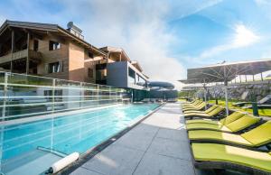 莱奥冈瑞德仁安雷蒙酒店的一座游泳池,旁边设有黄色躺椅