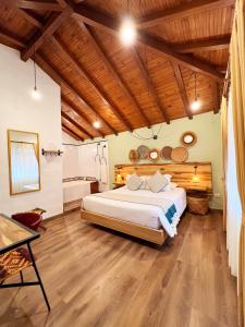 莱瓦镇Sie Casa Hotel的一间卧室设有一张大床和木制天花板