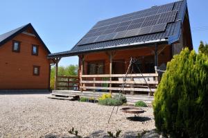 OdargowoSosenka Domki的屋顶上设有太阳能电池板的房子