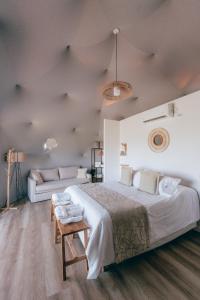 本塔纳山村Glamping Puente Blanco的一间卧室配有一张大床和一张沙发