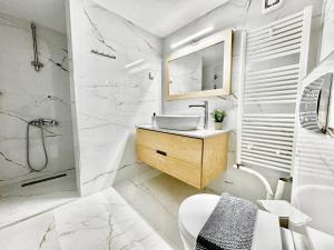 海若克利欧George Airport Apartments的白色的浴室设有水槽和淋浴。