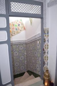 马拉喀什Al Bahja family的浴室的墙壁上铺有蓝色和白色的瓷砖。