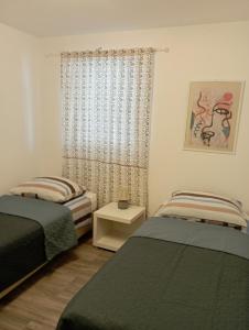 马斯莱尼察弗利根公寓的一间卧室设有两张床和窗户。
