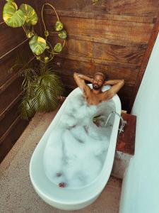 普拉亚科罗纳多La Maracuya Panama的坐在浴室浴缸里的男人