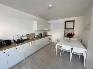 科克En-suite Double Room in Cork的厨房配有白色的桌子和白色的橱柜。