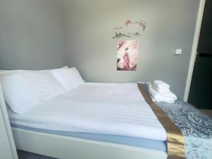 科克En-suite Double Room in Cork的一张带白色床单和枕头的床