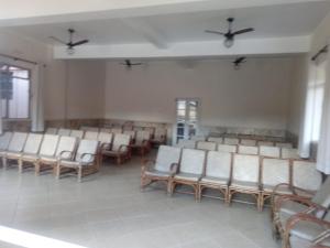 卡尚布Hospedagem Sul de Minas Caxambu的一间空的等候室,配有白色的椅子和窗户