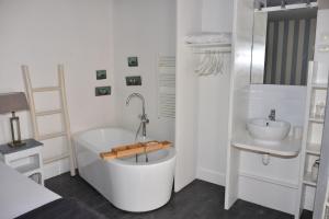 比斯卡罗斯La Villa du Grand Large的白色的浴室设有浴缸和水槽。