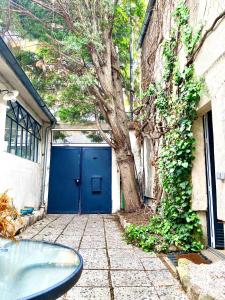 巴黎Artist's Home - Villa & Private Courtyard - 200m2的建筑物前有一棵树的蓝色门