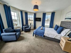 LongtownGraham Arms Inn的一间卧室配有蓝色窗帘、一张床和椅子