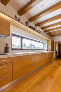BrocēniBlack Swan的一个带木制橱柜和大窗户的厨房