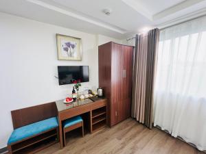 河内Khách Sạn 239的酒店客房配有书桌和电视。