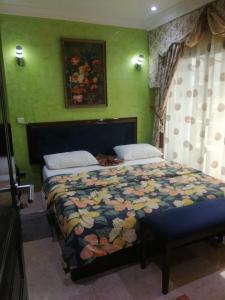 布拉柴维尔Hôtel LE PÉRIDOT的一间卧室配有一张带五颜六色棉被的床