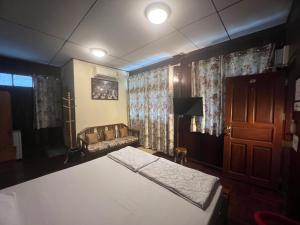 大城班恒民宿的一间卧室配有床、沙发和窗帘