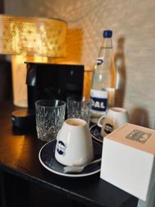 杜柏La Grainerie的一张桌子,上面放着两杯咖啡和一瓶苏打水