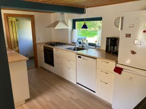 莱斯Mor’s hus Læsø的厨房配有白色橱柜、水槽和冰箱。