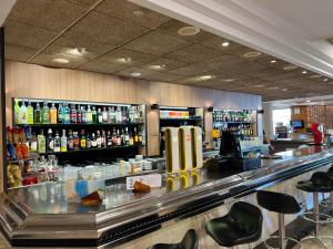 罗列特海岸阿斯托利亚公园酒店的酒吧配有吧台、凳子和酒瓶