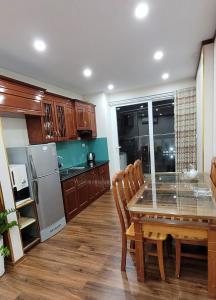 下龙湾Homestay Ha Long Luxury Apartment ( Ocean View)的厨房配有桌椅和冰箱。