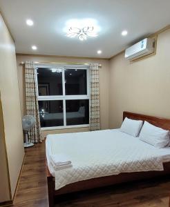 下龙湾Homestay Ha Long Luxury Apartment ( Ocean View)的一间卧室设有一张床和一个窗口
