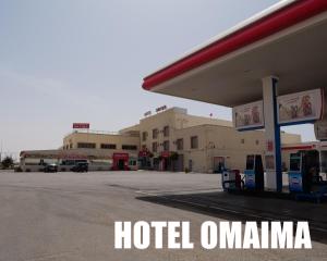 阿尤恩Hotel OMAIMA的加油站前的酒店标志