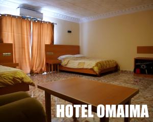 阿尤恩Hotel OMAIMA的酒店客房设有两张床和一张桌子。