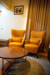 拉各斯Box Residence Hotel的两个橙色椅子和一张桌子
