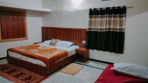 卜山Laxmanji villas的一间带床和窗帘的小卧室