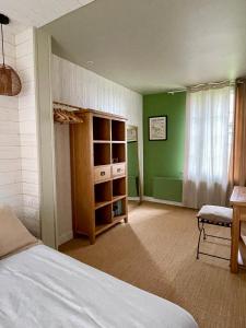 梅斯尼圣佩尔Les Cottages d'Orient Premium的一间卧室设有一张床和绿色的墙壁