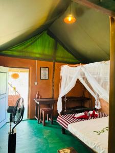 蒂瑟默哈拉默Animal View Point Yala的一间帐篷内的卧室,配有一张床和一张书桌